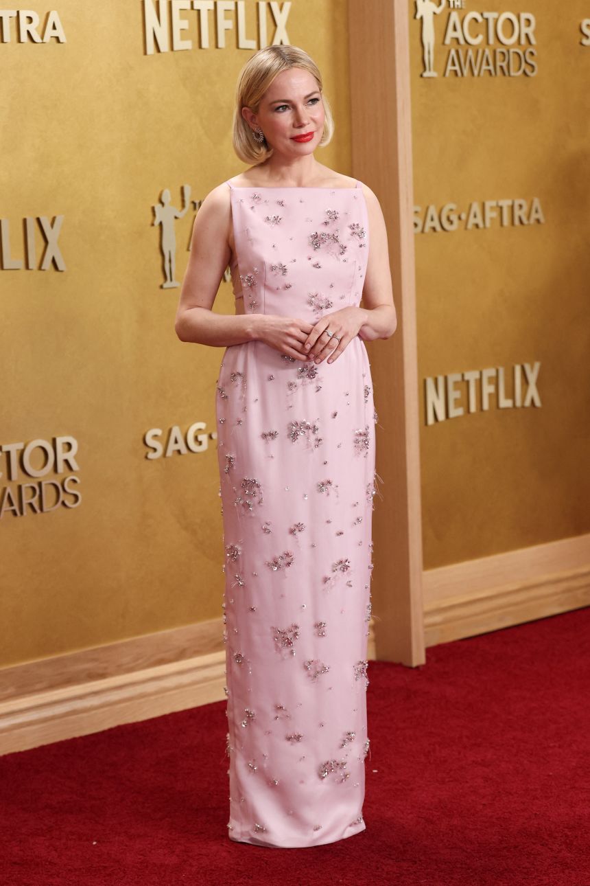 Michelle Williams’ pink Prada apron dress featured bouquet designs embroidered with crystals and tiny sequins.