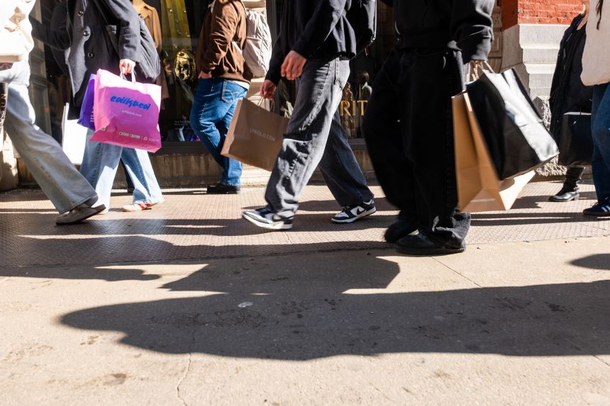 People walk along Broadway with shopping bags in Manhattan on February 27, 2026 in New York City.
