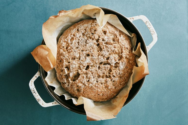 A glutenfree boule with chia seed flour resting in parchment paper in a Dutch oven.