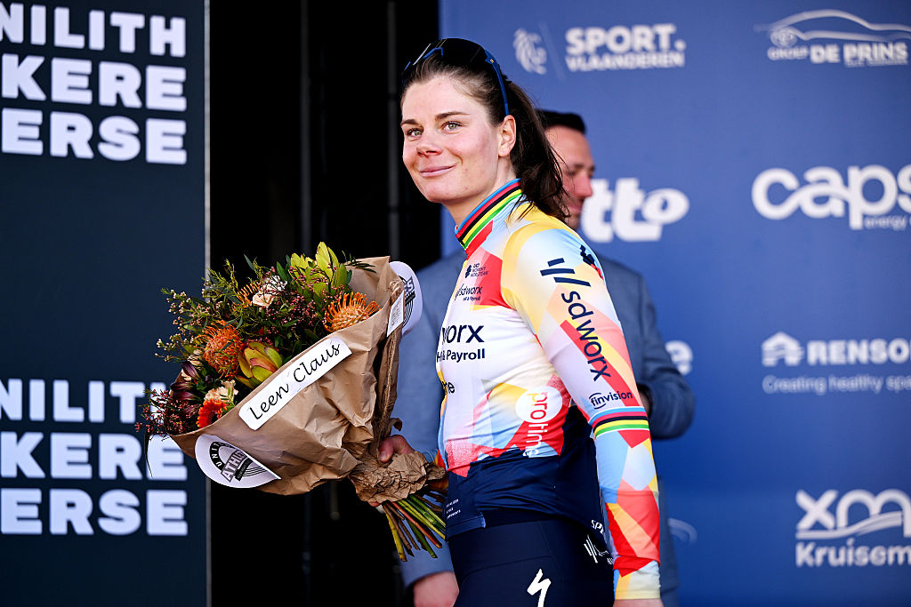 Lotte Kopecky smiles whilst holding a bouquet of flowers on the podium after winning Nokere Koerse Women 2026