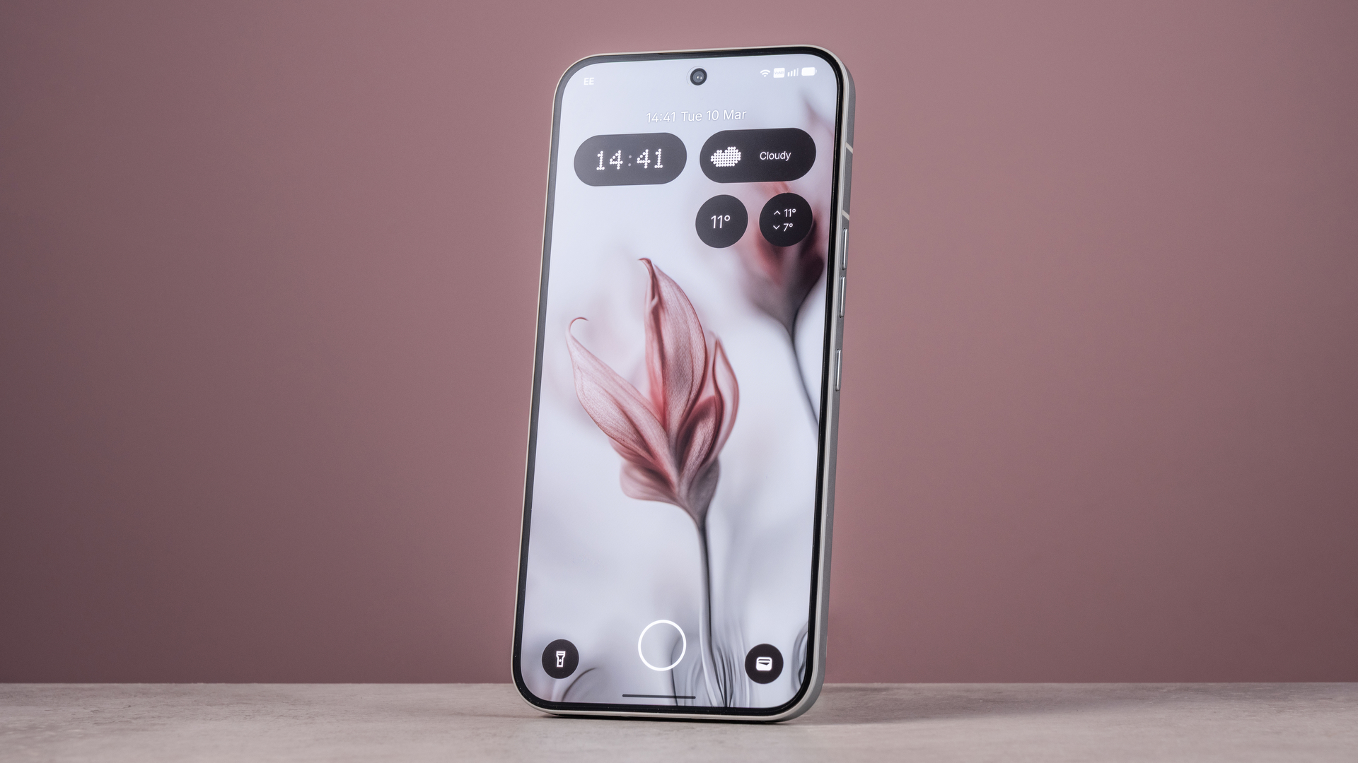 The Nothing Phone (4a) Pro's home screen featuring an AI image of flowers, in front of a pink background.