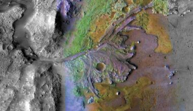 False color image of a crater wall with river delta deposits spreading into the crater from it.