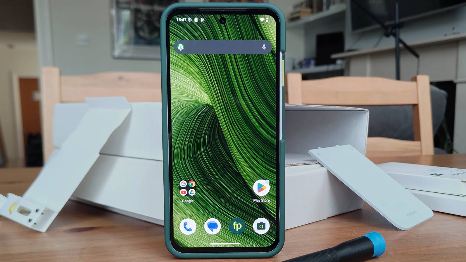 The Fairphone 6 standing before various boxes.