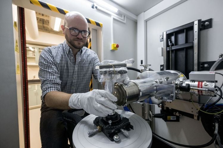 Study co-author and NASA X-ray scientist, Dr. Scott Eckley, seen loading a Bennu sample into an X-ray Computed Tomography (XCT) machine that was used for the study. (Credit: NASA/Robert Markowitz)