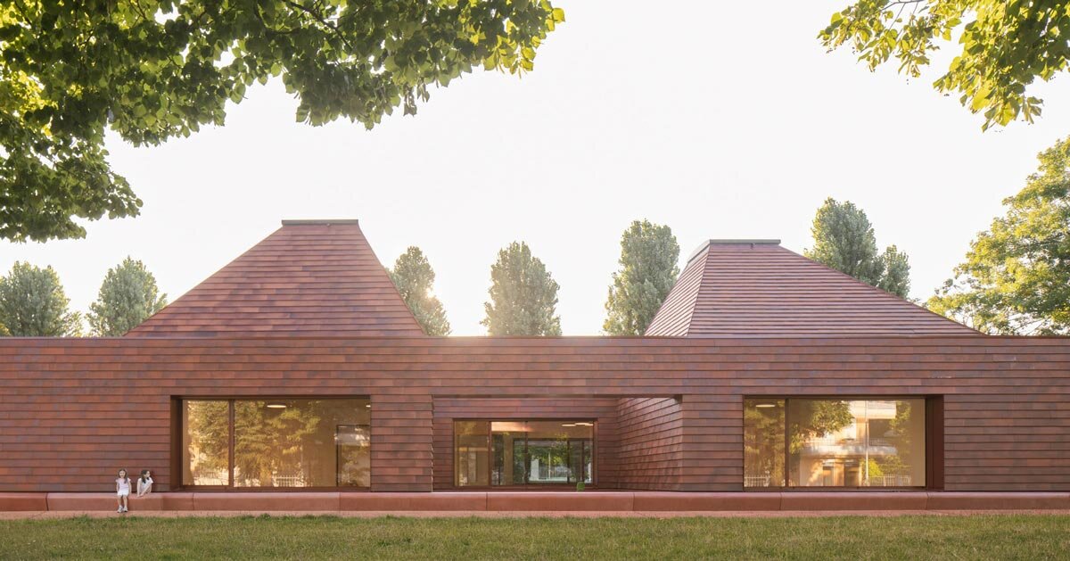 terracotta-tiled pyramidal houses envelope kindergarten in italy