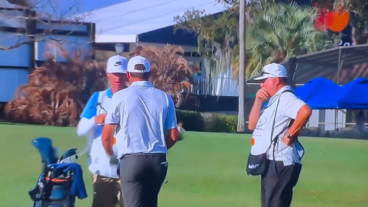 Larson (right) looking at Scheffler's club