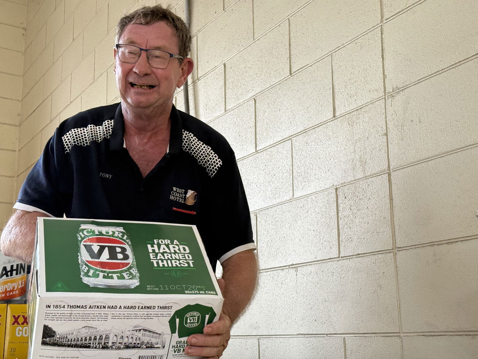 man in glass carrying carton of beer