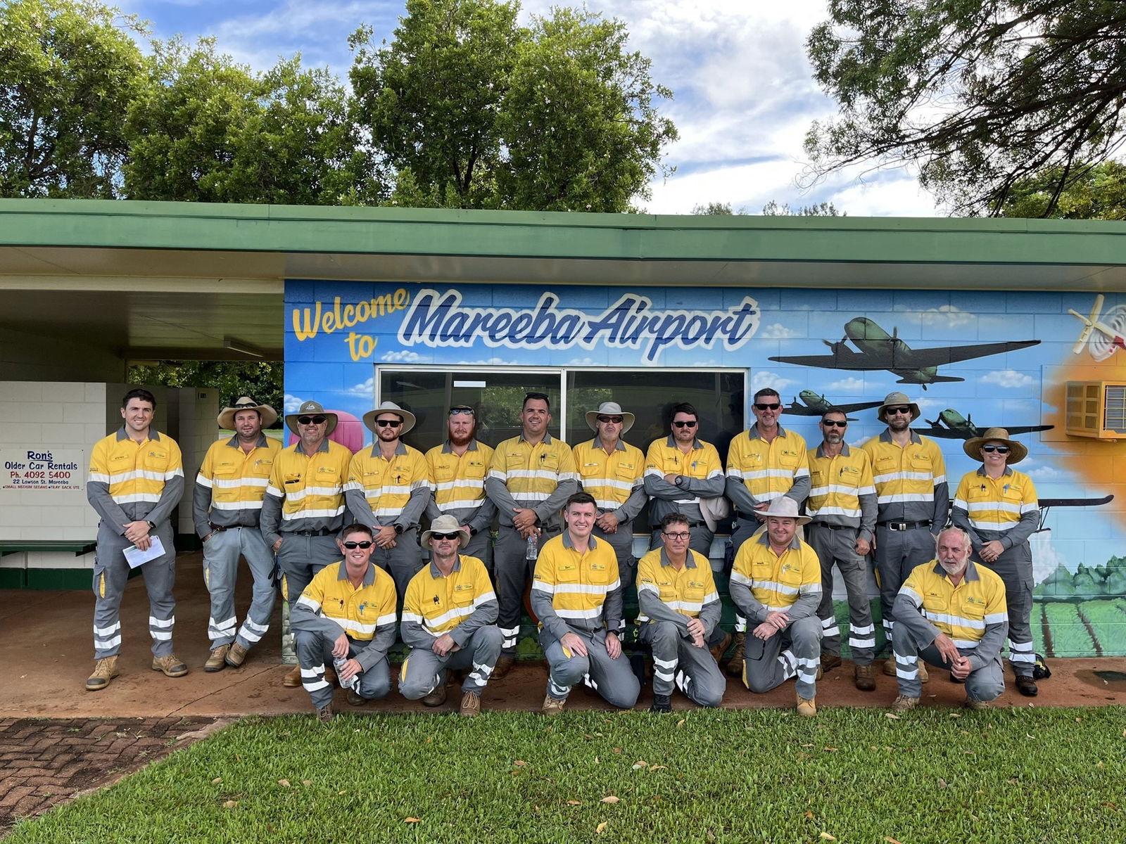 A group of people in high vis standing in front of Mareeba Airport. 