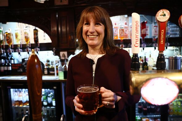 Rachel Reeves holds a pint behind pub bar