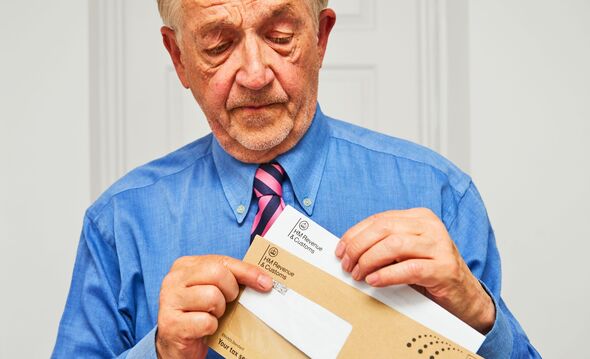 A man opens a letter from HM Revenue and Customs
