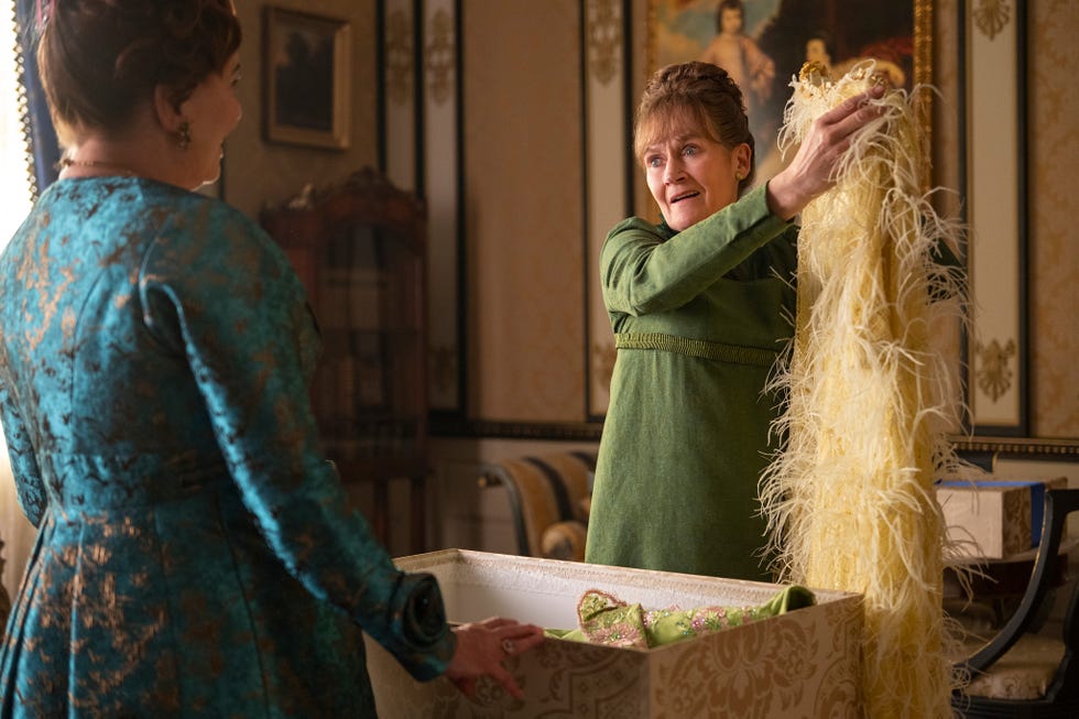 two individuals in a vintage interior examining a costume or garment