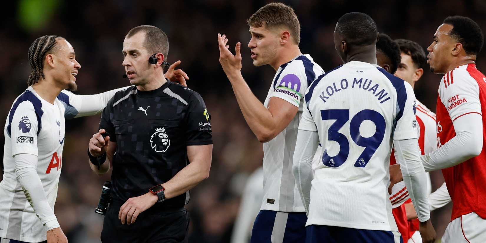 Tottenham and Arsenal players argue with the referee