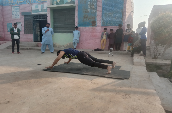 Muhammad performing thumb push-ups with an audience watching him