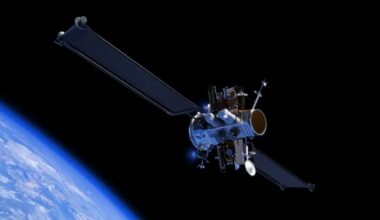 a satellite with many parts floats in space above Earth.