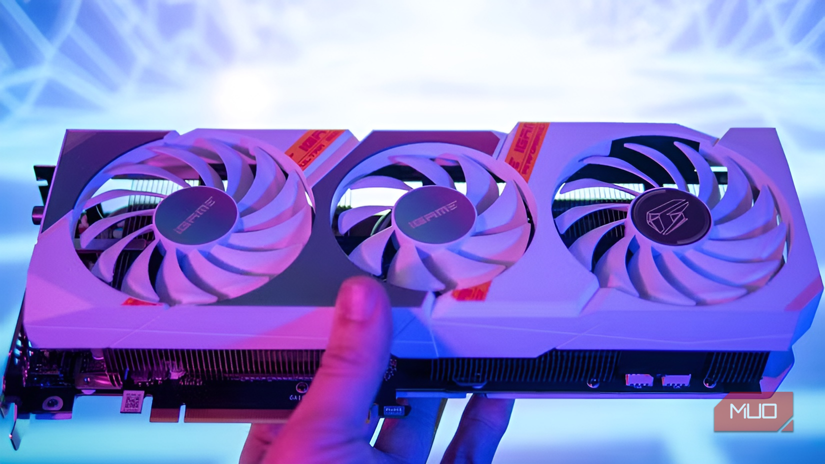 Person holding the white triple-fan iGame GeForce RTX 3060 graphics card to show its front design.-1