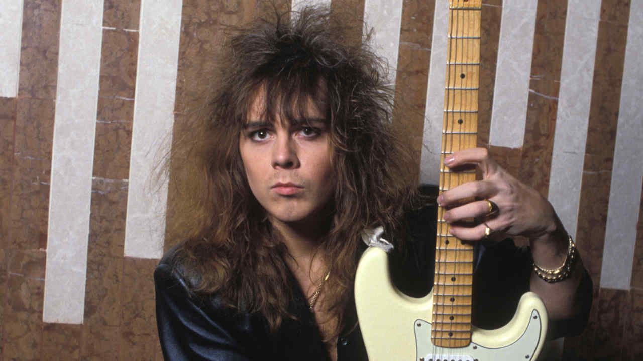 Ynwgie Malmsteen holding a guitar
