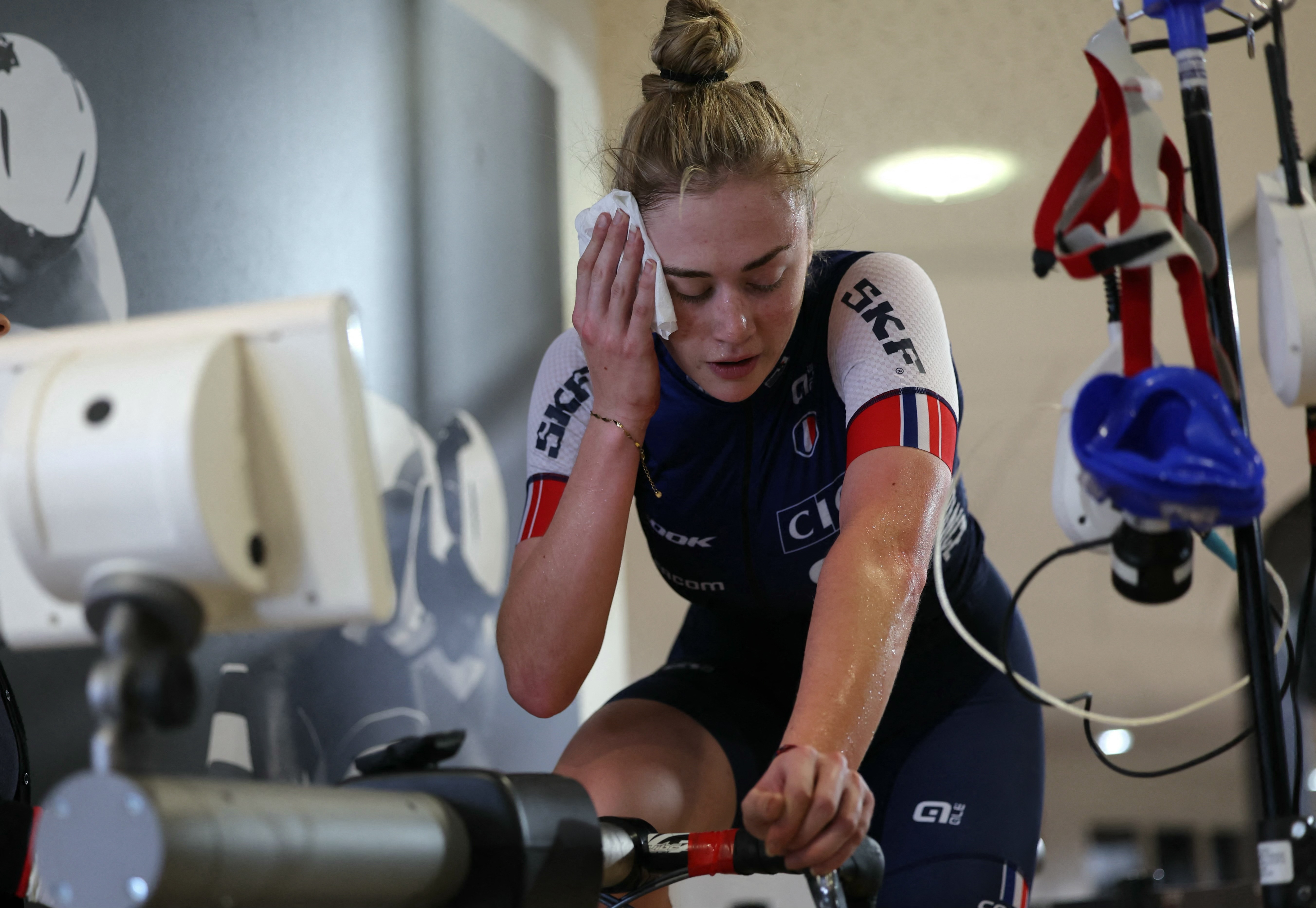 French cyclist Lara Lallemant (R) takes part in a training session with a Cycling Federation sport scientist, French Iris Sachet, as she studies her physiological profile, to feed research on high performance atheletes and prepare the French athletes for the 2024 Olympic Games of in Paris, at the French National Velodrome of Saint-Quentin-en-Yvelines on January 31, 2024. Athlete profiling, 3D scans of the velodrome, twin mannequins, artificial intelligence and marginal gains: French cycling is banking on the hard sciences to shine at the Paris Olympics and take on the Anglo-Saxon pioneers at their own game. (Photo by Thomas SAMSON / AFP)