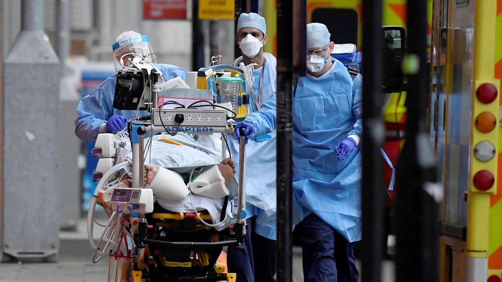 Medical workers move a patient between ambulances during the COVID pandemic. Pic: Reuters