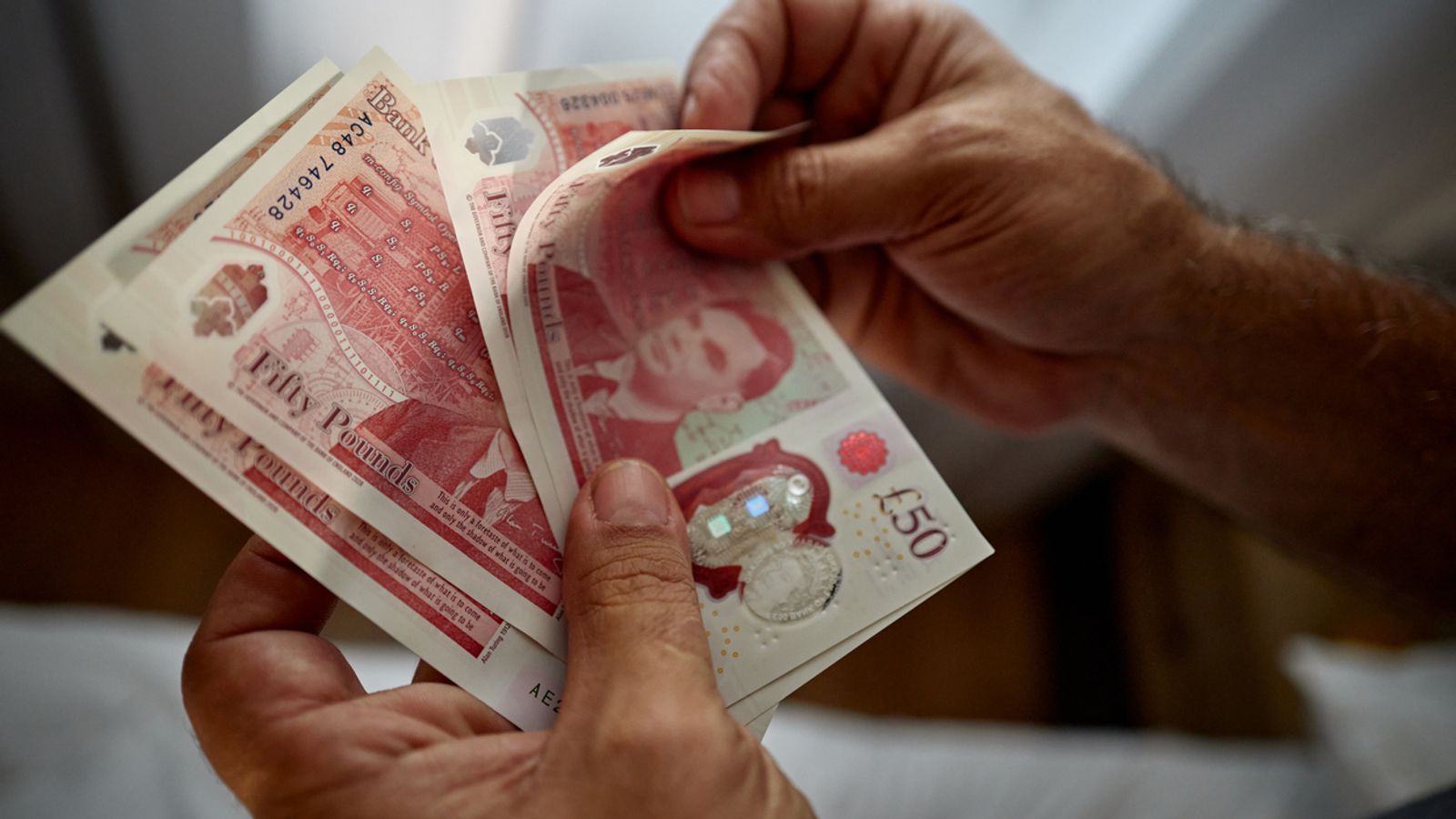 Close up of unrecognizable man counting £50 notes. Pic: iStock
