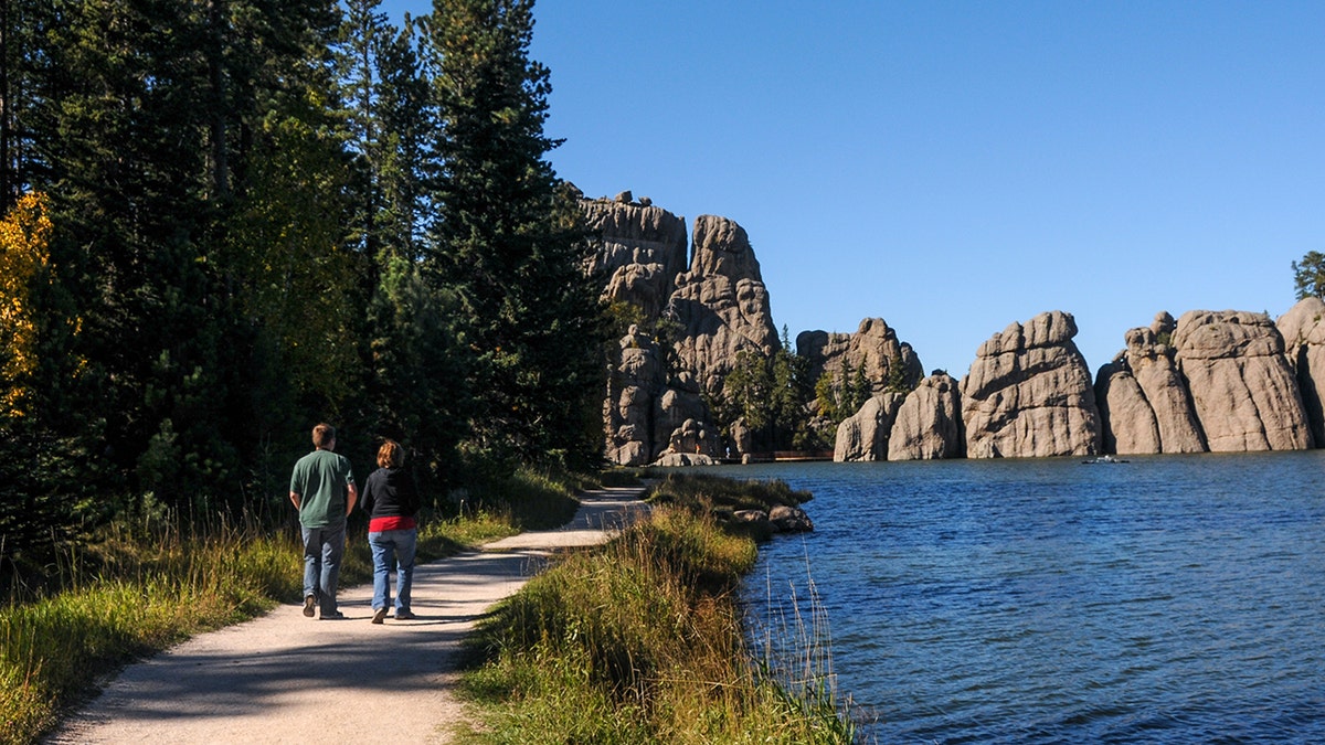 Couple walks alongside lake in South Dakota.