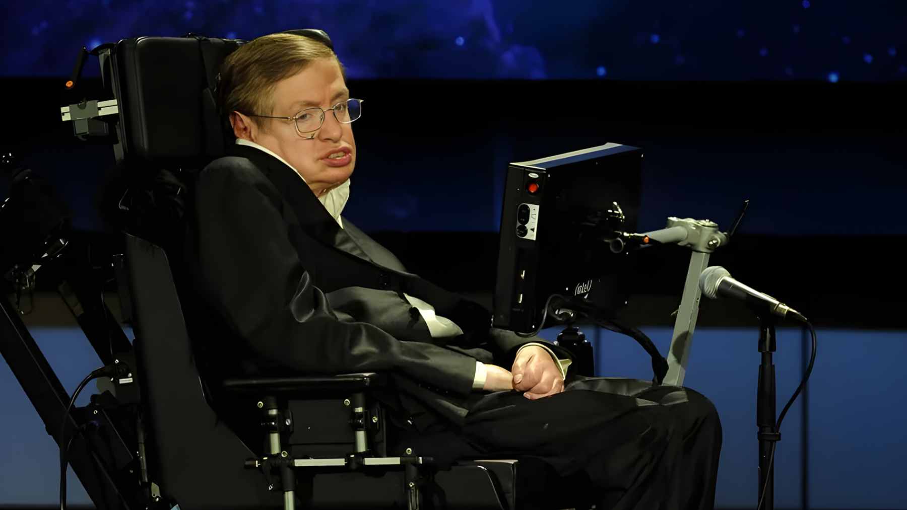 Physicist Stephen Hawking using his specialized communication system to deliver a lecture on the future of humanity and space exploration.