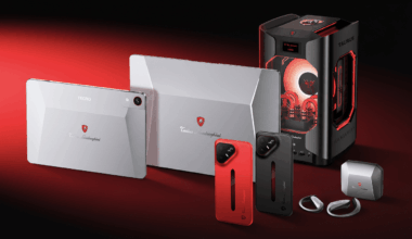 A collection of Tonino Lamborghini branded tech products, including a tablet, laptop, two smartphones (one red, one black), a desktop computer tower, and earbuds, all displayed on a red background.