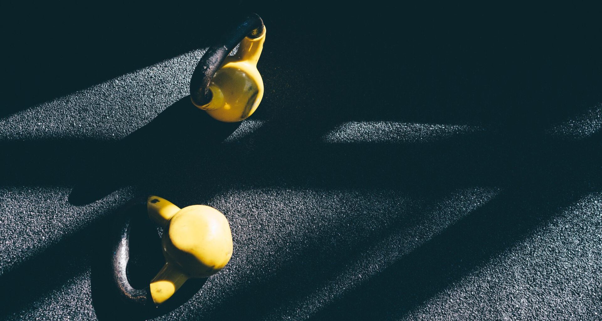 Two kettlebells lying on floor for farmer's carry exercise