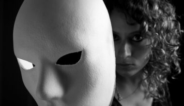 Young woman reveals her face behind white mask.