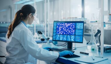 A pharmaceutical lab technician is working at a computer.