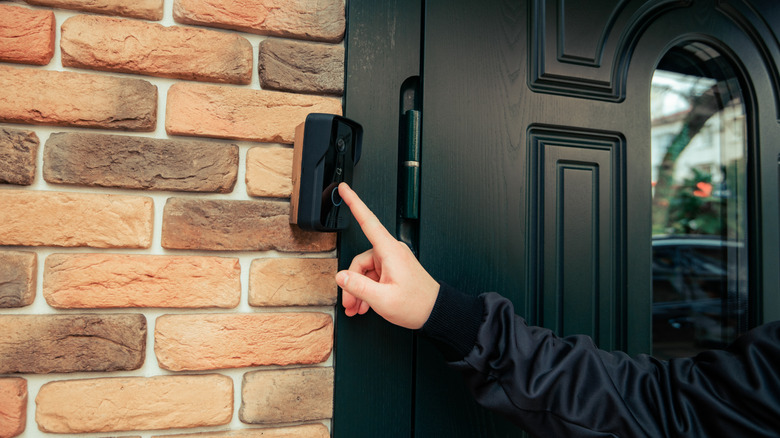 Finger pressing a Ring Video Doorbell