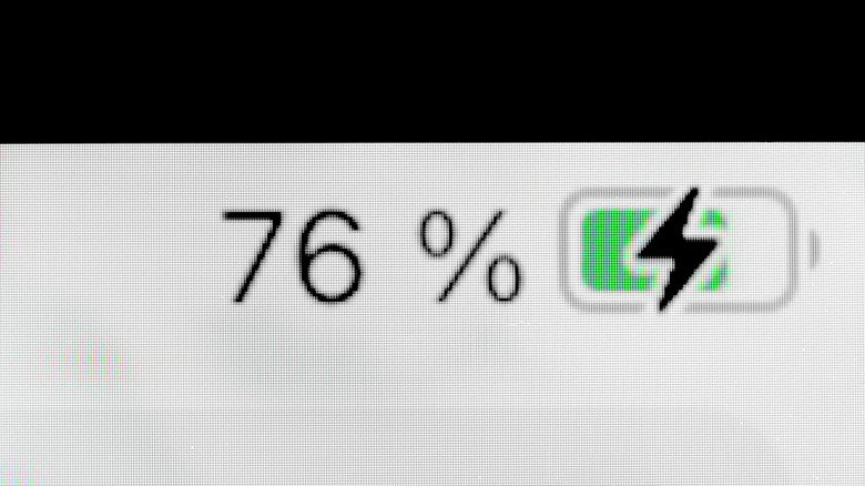 Close up of a phone display showing the battery charging symbol