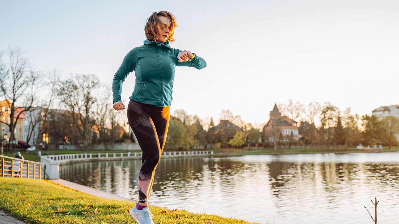 Female jogging by a lake in the morning