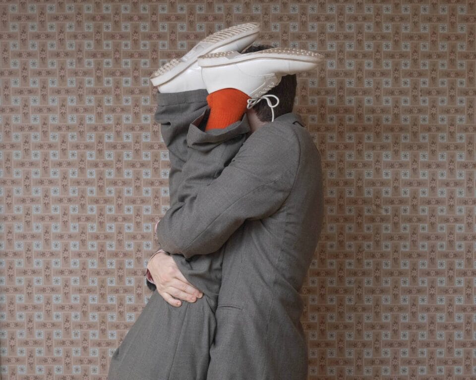 a surreal portrait by photographer Ben Zankn depicting a figure clutching two legs, almost as if he is contorted in a tense way