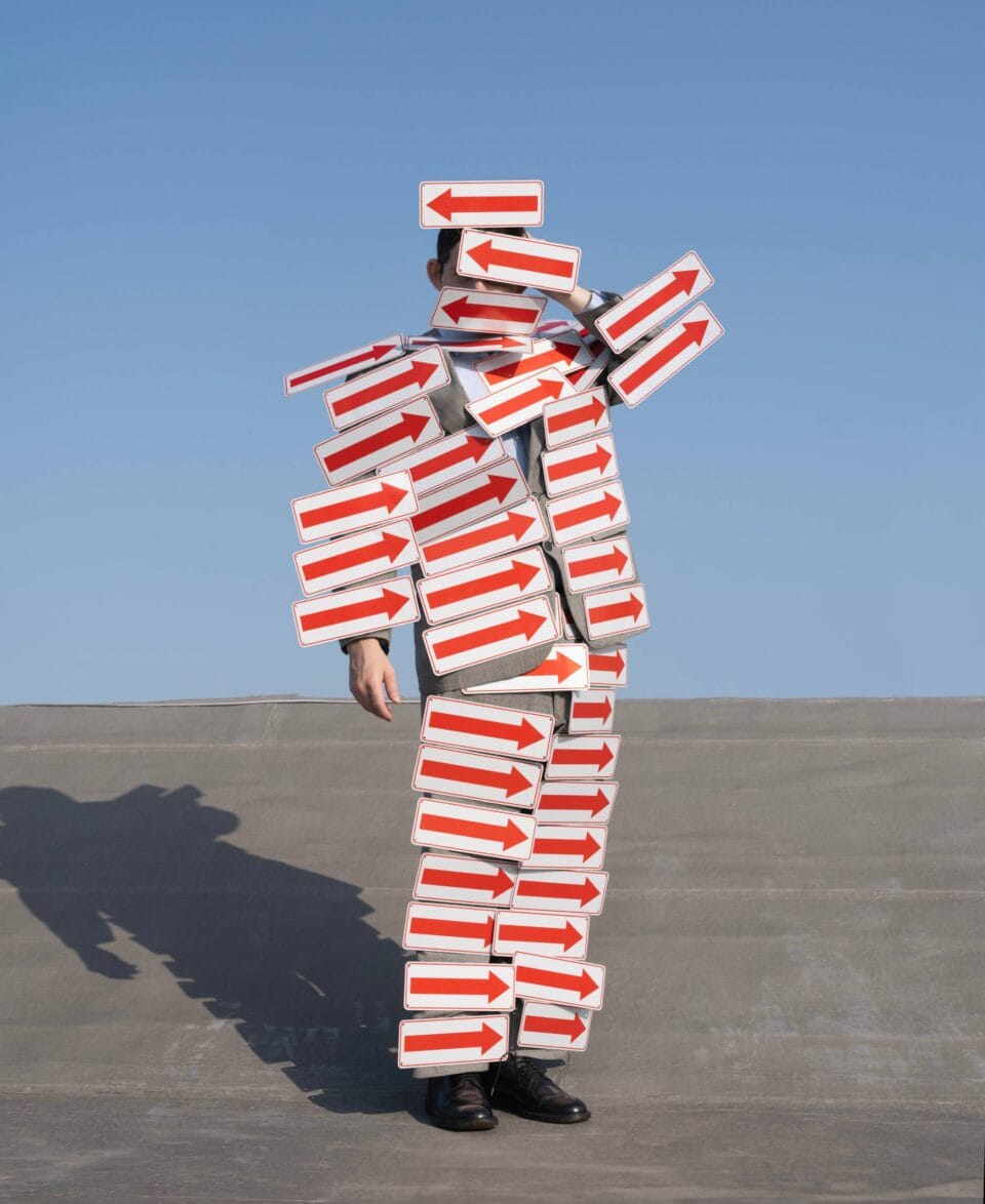 a surreal portrait by photographer Ben Zankn depicting a figure covered in arrow signs