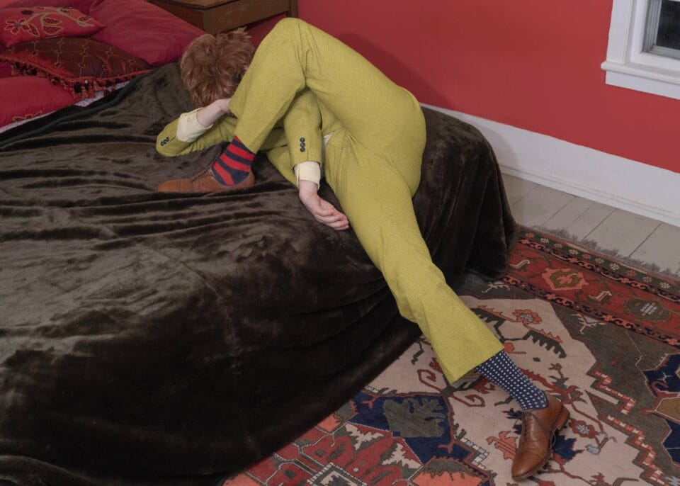 a surreal portrait by photographer Ben Zankn depicting a contorted figure sliding off the edge of a bed