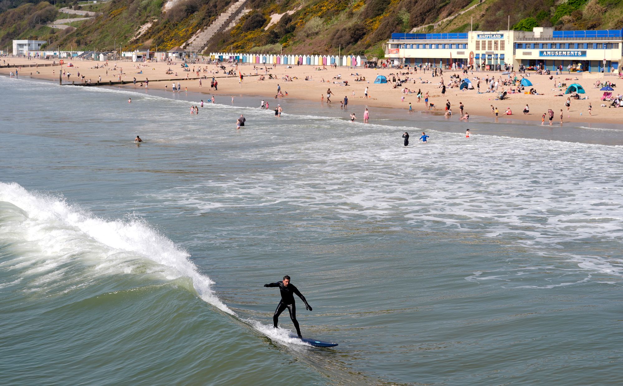 A surfer hits the waves in the sea off of Bournemouth beach in Dorset
