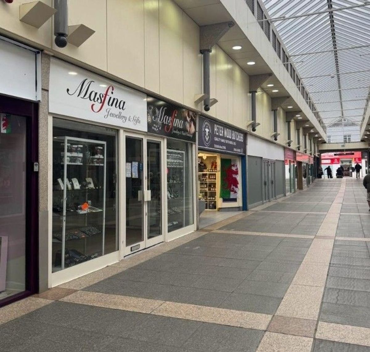  Historic market doors are closed, shop windows empty, and lights are off in many of the units