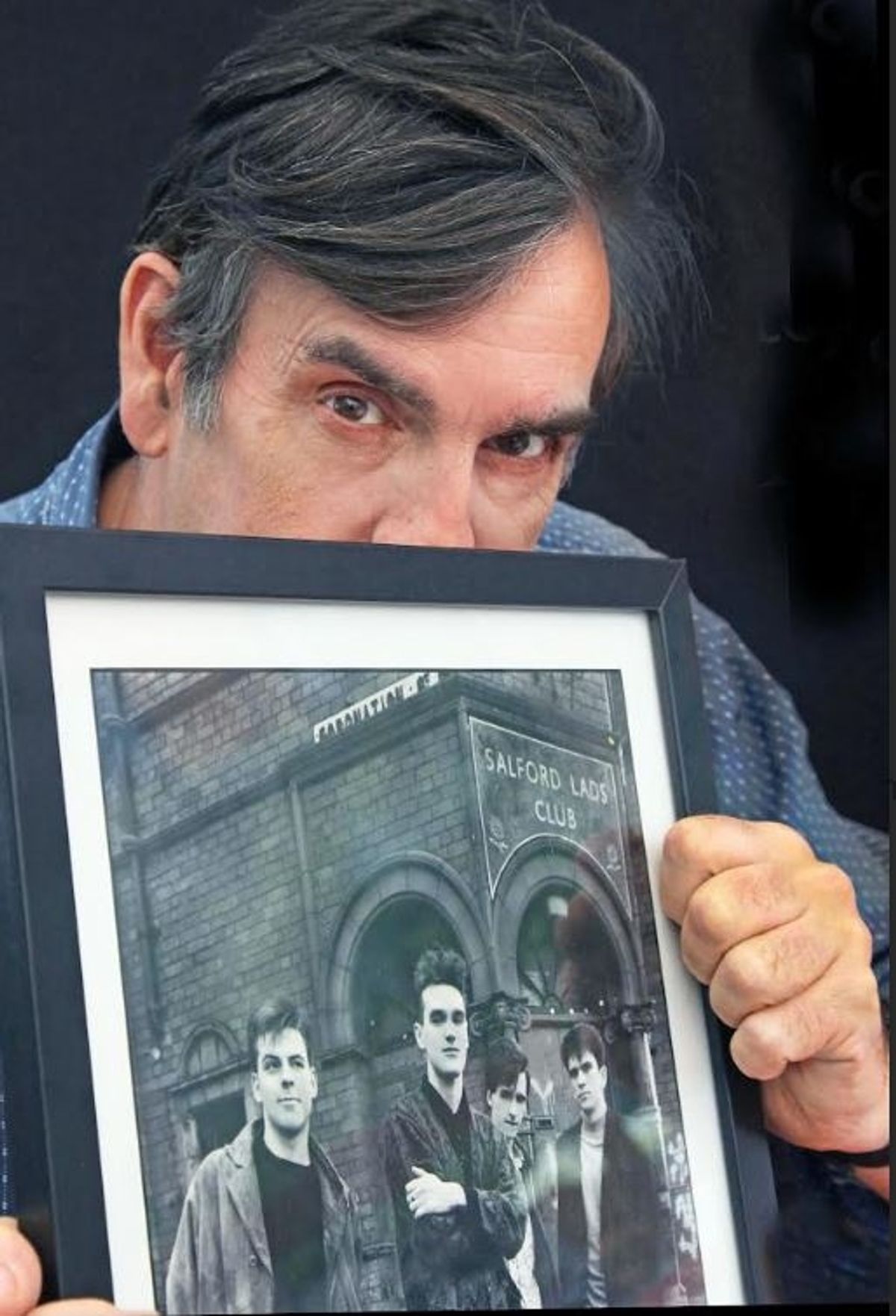 Stephen Wright with a print of his iconic image of The Smiths taken outside Salford Lads Club