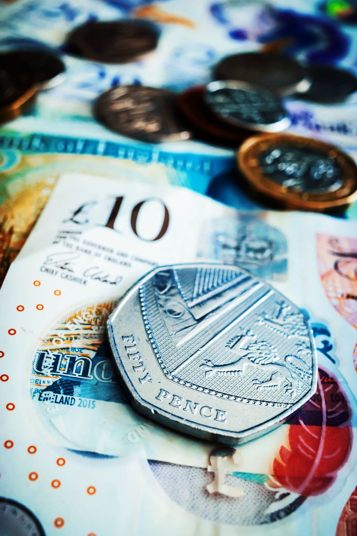 Fifty pence coin on various English banknotes