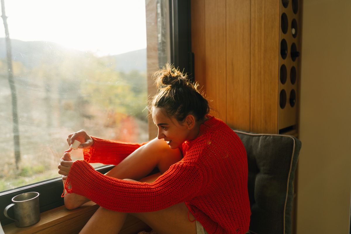 Photo of a young woman doing a pedicure at home.