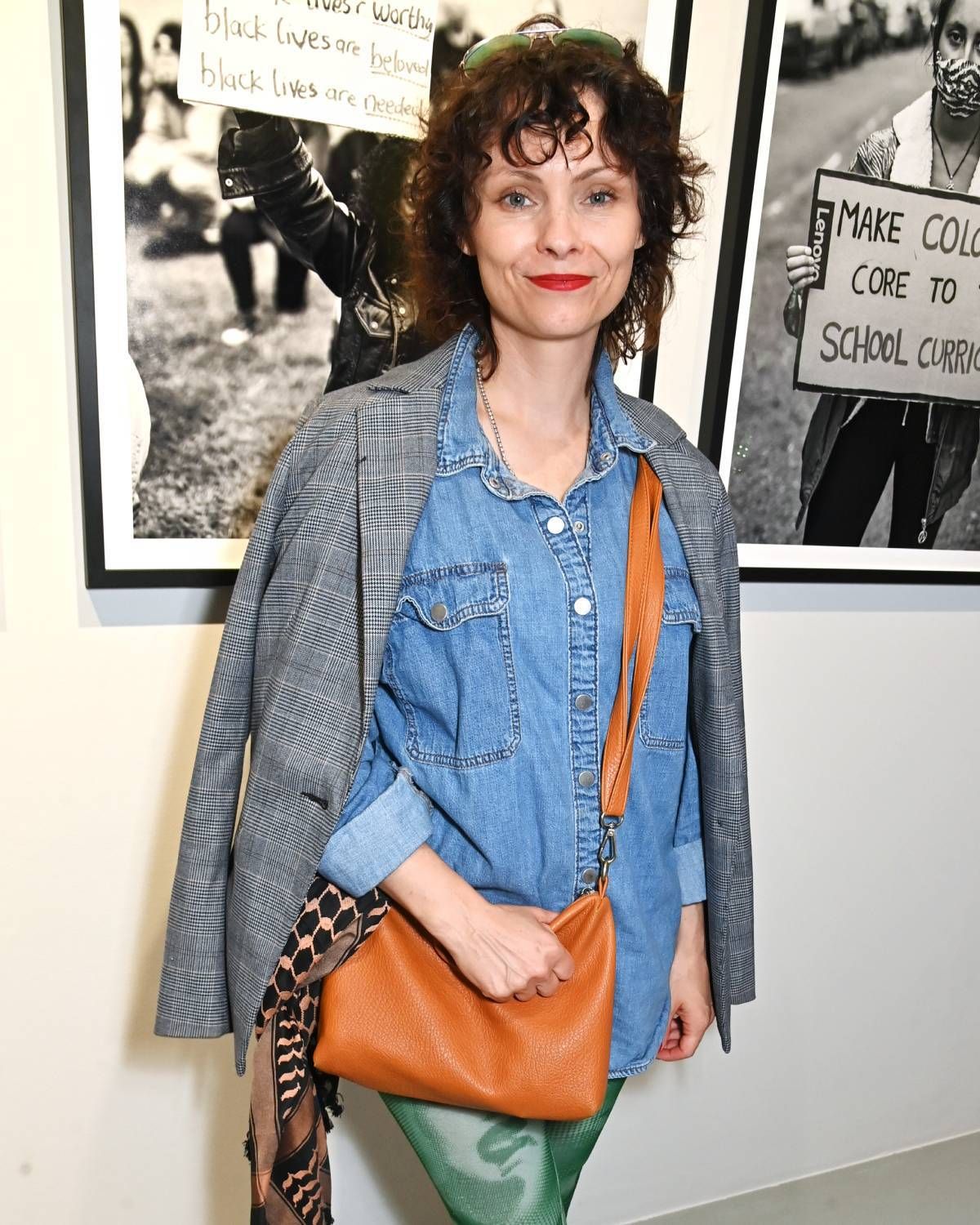 A brunette woman wearing a denim shirt and blazer.