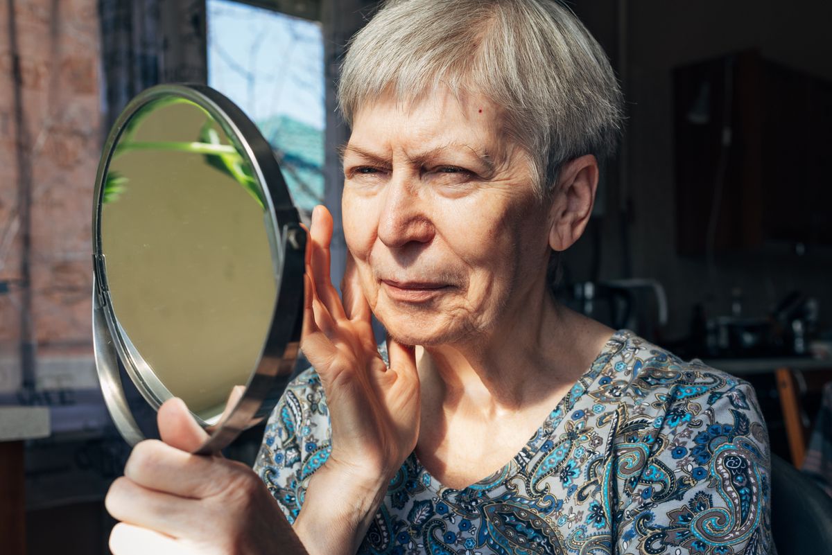 Woman looking at her face