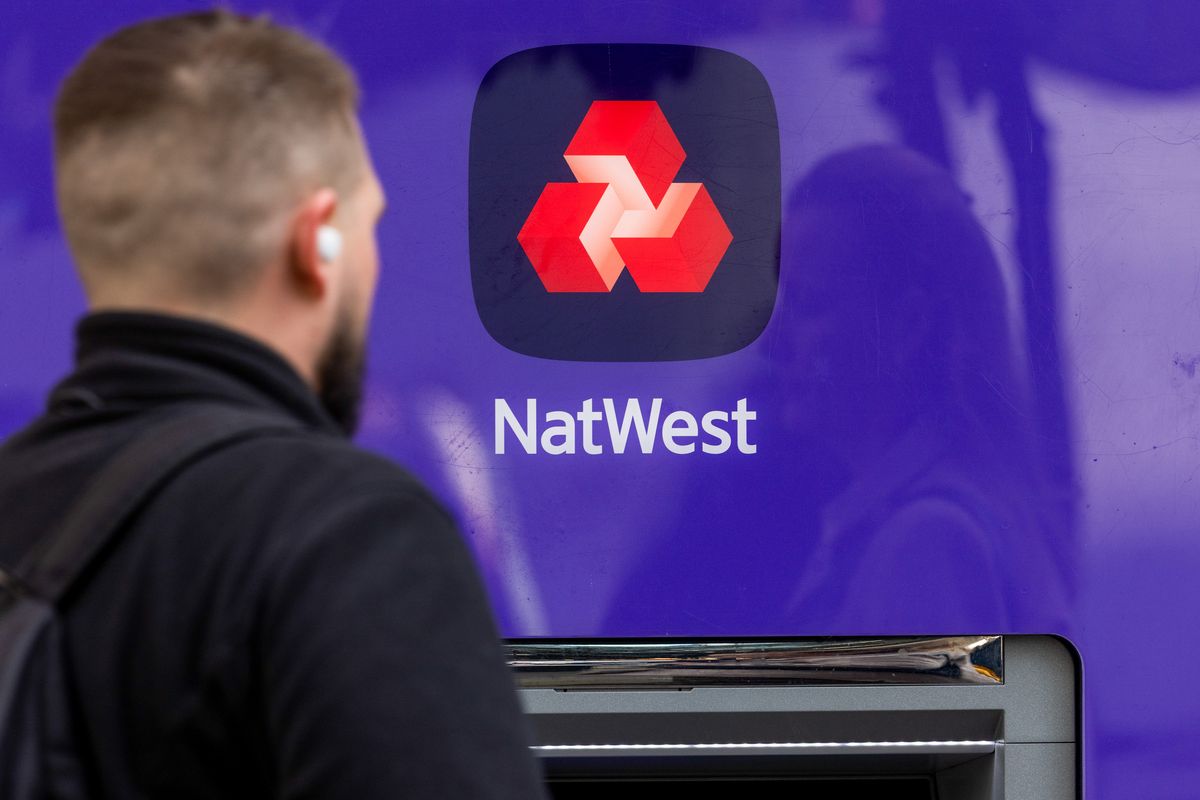 A sign above an automated teller machine (ATM) outside a NatWest Group Plc bank branch in London, UK, on Friday, Feb. 6, 2026. NatWest Group Plc agreed to buy wealth manager Evelyn Partners, as the British bank looks to increase its access to affluent clients in its home market. Photographer: Chris Ratcliffe/Bloomberg via Getty Images
