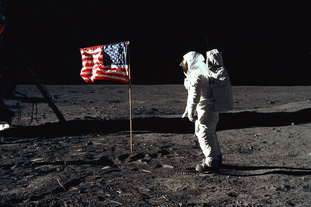 Astronaut Edwin E. Aldrin, Jr., the lunar module pilot of the first lunar landing mission, stands next to a United States flag July 20, 1969 
