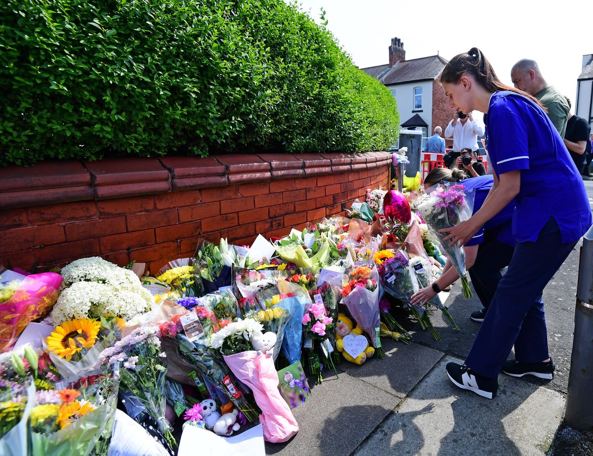 Nurses lay tributes at the Southport attack scene.
