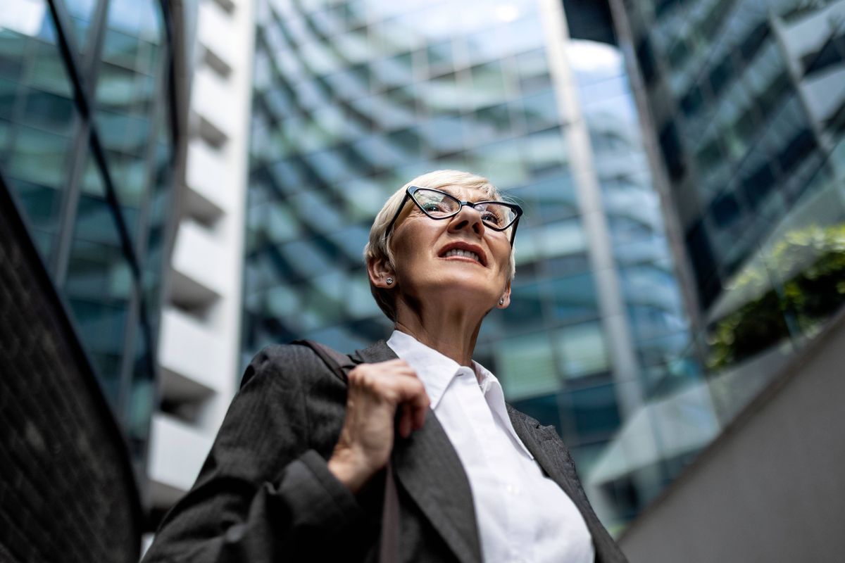 Mature businesswoman walking outside office building