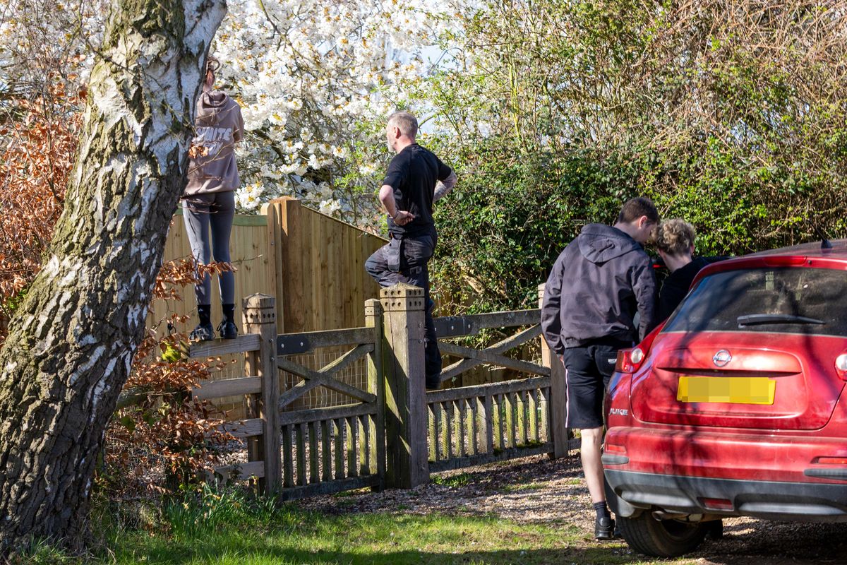 man and woman climbing gate outside Marsh Farm