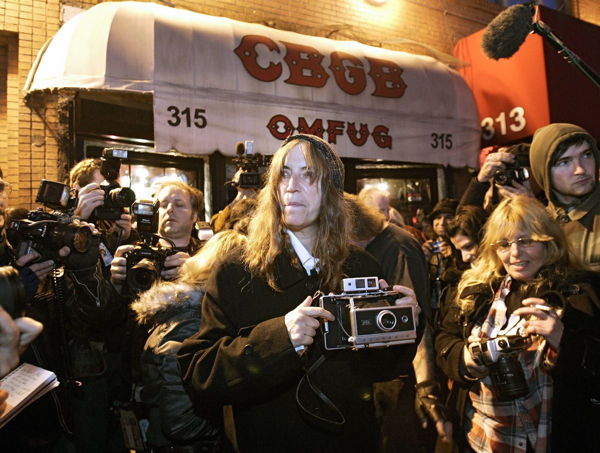 Rock star and poet Patti Smith (C) comes outside to take pictures of CBGB, New York's most famous punk bar on its closing night 15 October 2006 after 33 years. Smith was the final performer in the club