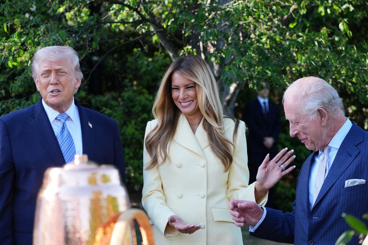 First Lady Melania Trump and Britain's King Charles III share a laugh as President Donald Trump looks on during a tour of the White House beehive