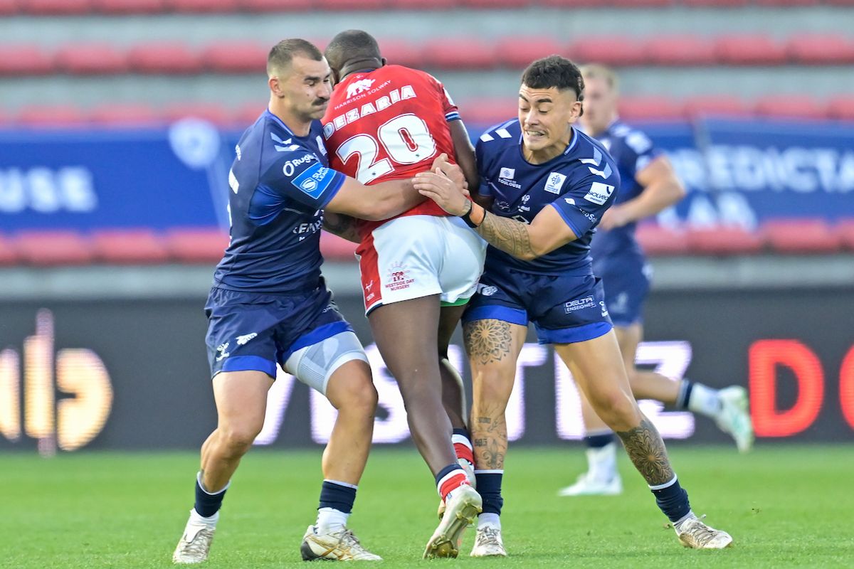  Hull KR's Jordan Dezaria tackled by Toulouse Olympique's Mathieu Jussaume and Tiaki Chan